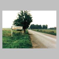 065-1028 Das russische Ortsschild, zeigt den ehemaligen deutschen Ort  Moterau an. Rechts im Bild sind Gebaeude vom Hof Rose (1993).jpg